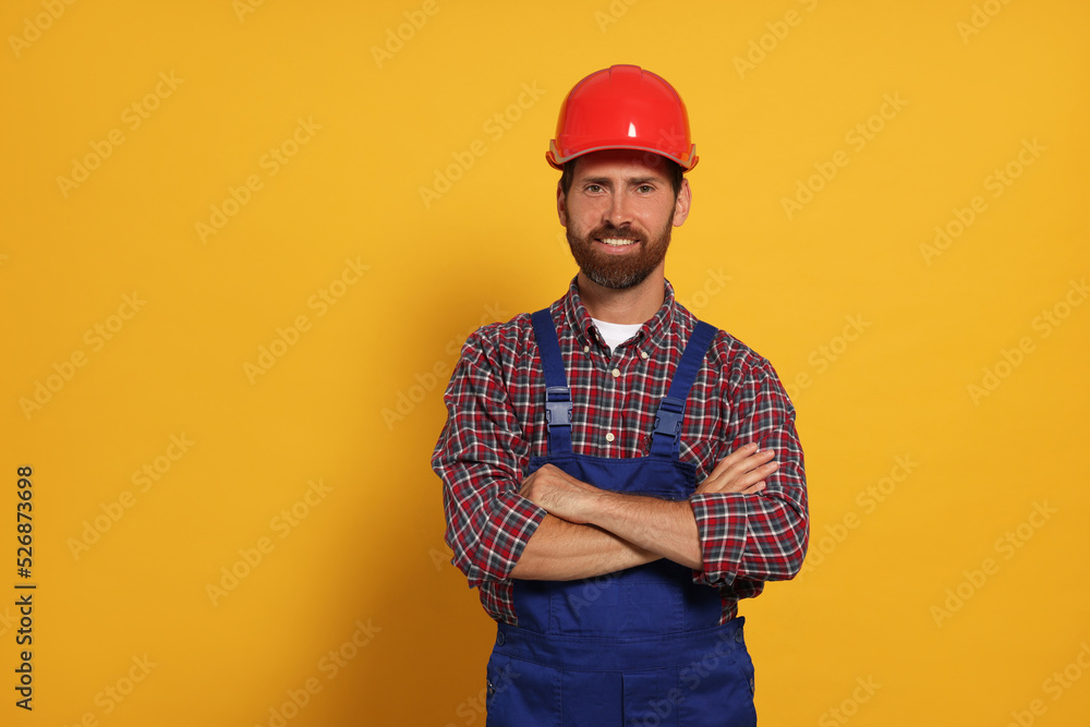 Professional builder in uniform on yellow background Professional builder in uniform on yellow background