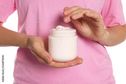 Woman taking hand cream from jar on white background, closeup