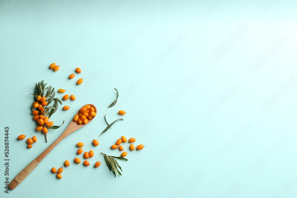 Fresh ripe sea buckthorn on light blue background, flat lay. Space for text