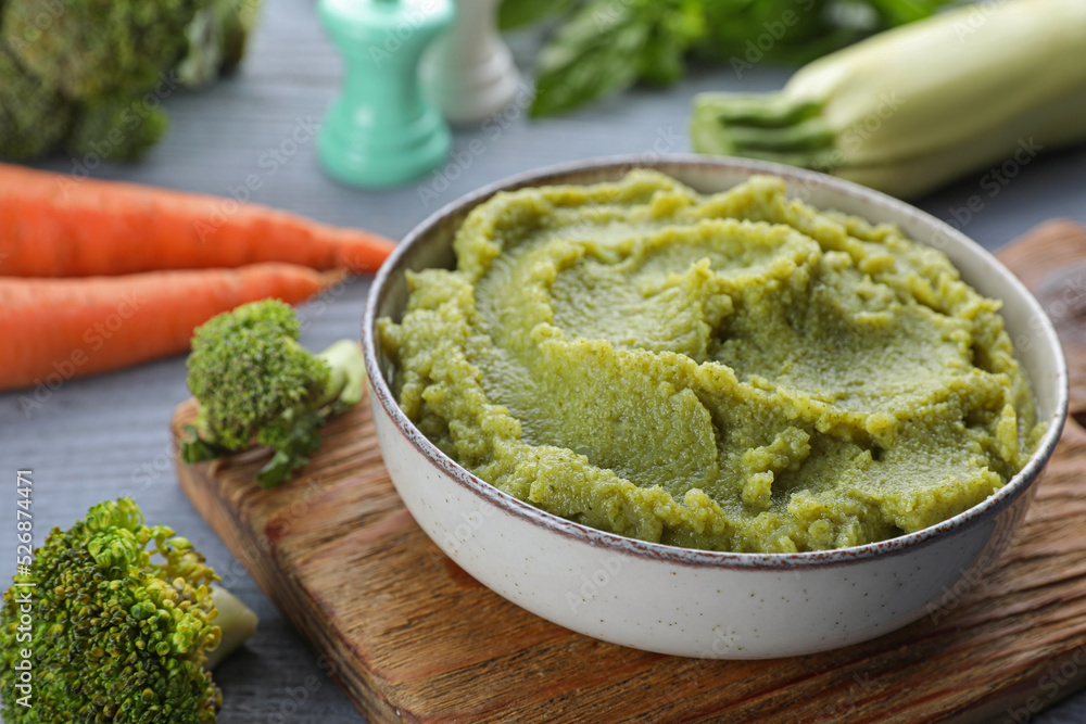 Bowl with tasty green puree and ingredients on light blue wooden table, closeup Bowl with tasty green puree and ingredients on light blue wooden table, closeup