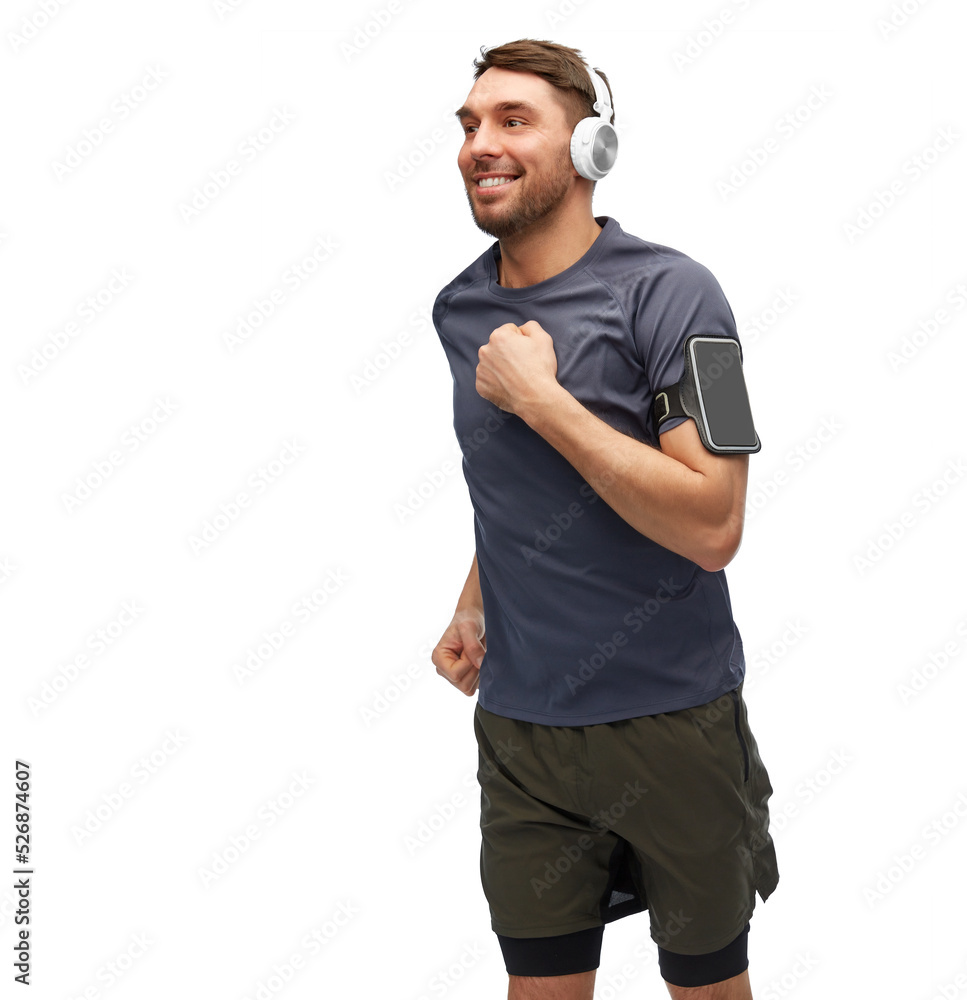 fitness, sport and healthy lifestyle concept - happy smiling man in headphones with smartphone in armband running over white background