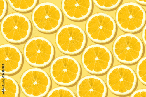 Citrus fruits pattern. Fresh lemon slices on light yellow background