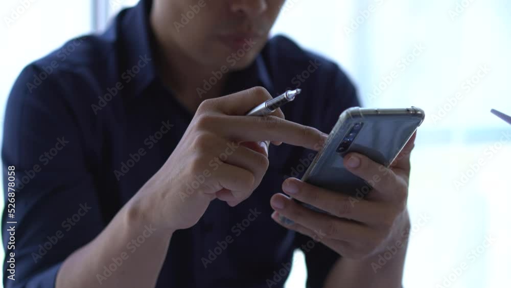 Asian man holding and using cellphone for searching data and social medie on internet. Asian man holding and using cellphone for searching data and social medie on internet.