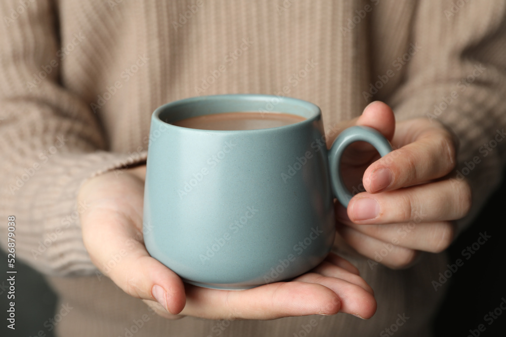 Woman holding cup of delicious hot cocoa, closeup Woman holding cup of delicious hot cocoa, closeup