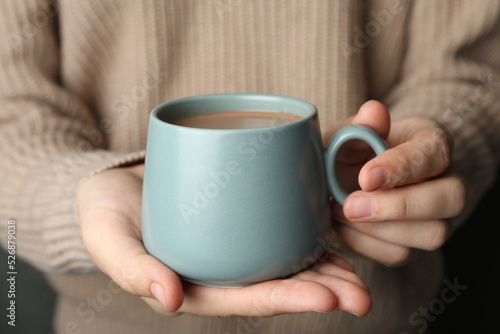 Woman holding cup of delicious hot cocoa, closeup