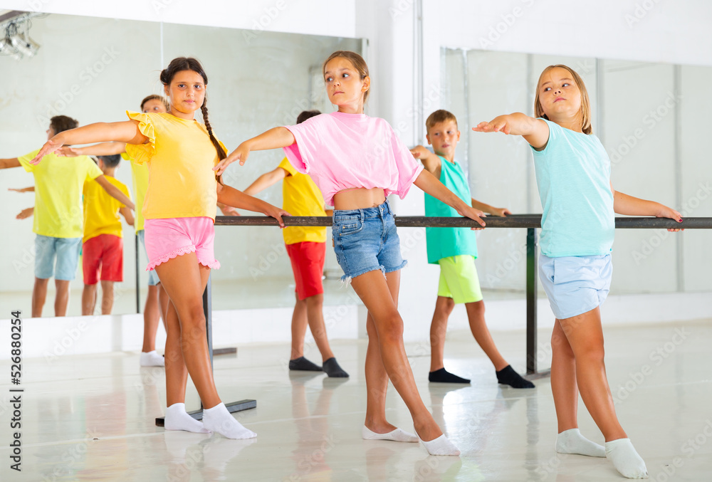 Young boys and girls training together during group ballet class.
