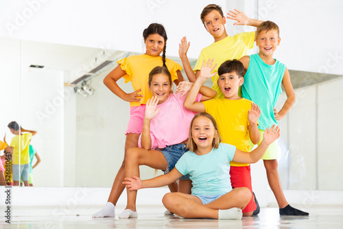 Group photo of young boys and girls posing in dance studio.
