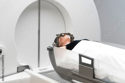 The patient lies in front of the device for the treatment of cancer with a gamma knife. She has a metal clip cap on his head. Gamma Knife stereotactic radiosurgery. photo