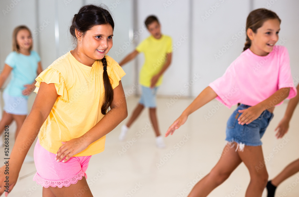Smiling Latin American Preteen Girl Training Movements Of Modern Vigorous Dance With Group Of Smiling Latin American Preteen Girl Training Movements Of Modern Vigorous Dance With Group Of