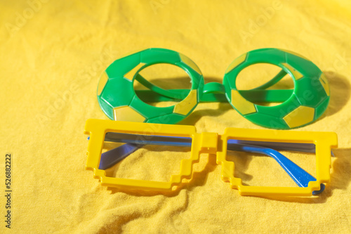 Glasses with Brazil colors, yellow and blue green, world cup concept with yellow background