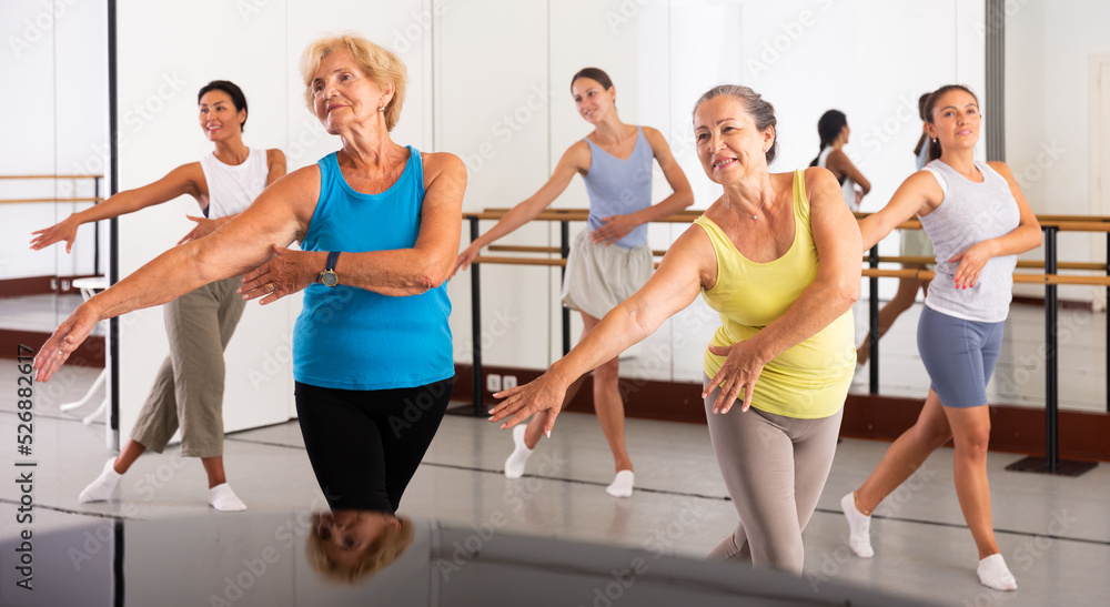 Obraz premium Group of various aged women dancing modern dance in studio.