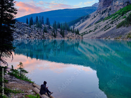 Relaxing with a good book and a great sunset with the reflection of the mountains on Moraine Lake