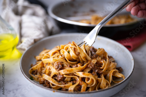 Carta da parati lifting up fettuccine ragu with fork