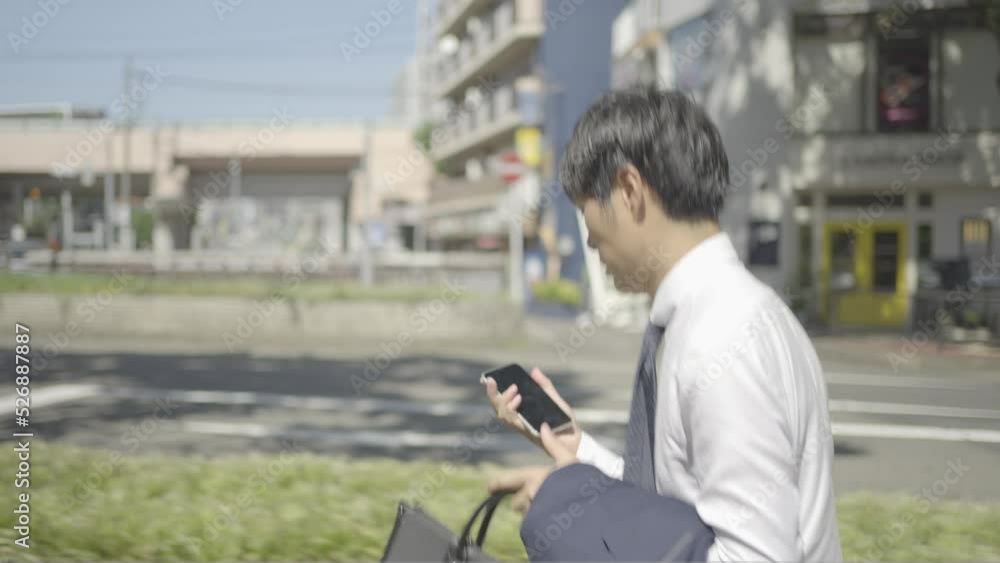 街中を歩きながら電話するビジネスマン 街中を歩きながら電話するビジネスマン