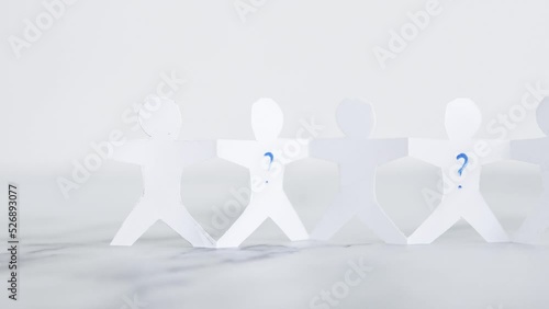 staff shortages and hiring personnel, paper people chain with question marks on some people symbol of positions to be filled photo