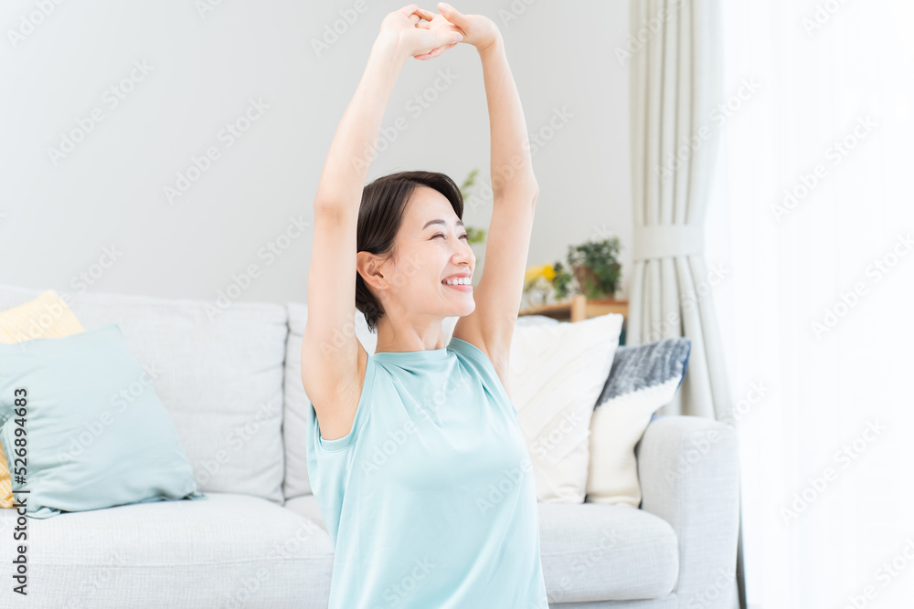 自宅で伸びをする日本人女性 自宅で伸びをする日本人女性