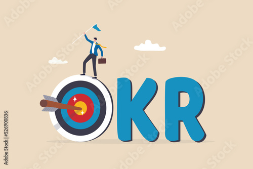 OKR, objective and key result framework to measure success and improvement, goal setting or define measurable target for business concept, businessman holding winning flag on target with the work OKR.
