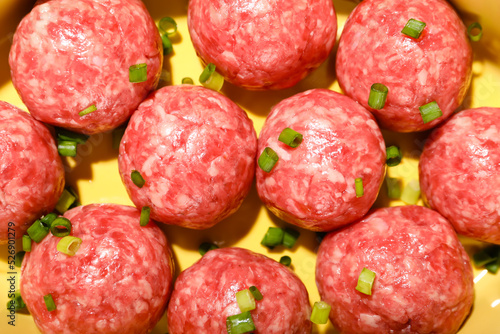 Raw meatballs with green on...