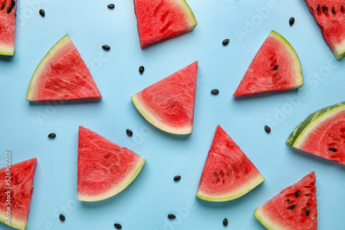 Slices of tasty watermelon with seeds on blue background