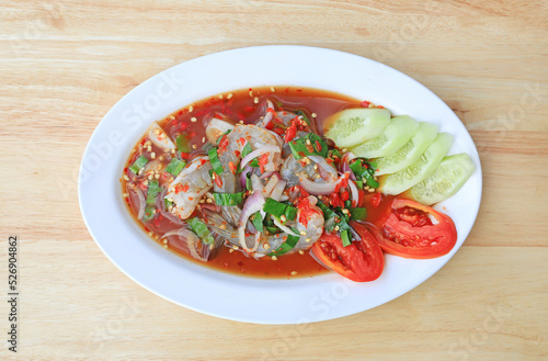 Shrimp spicy salad in dish on wood table background.