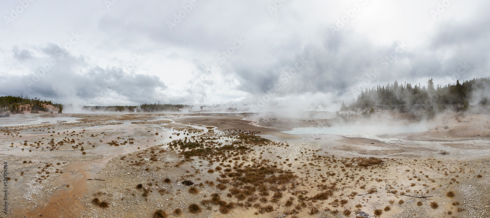 Hot spring Geyser with colorful water in American Landscape. Cloudy Sky. Yellowstone National Park, Wyoming, United States. Nature Background Panorama