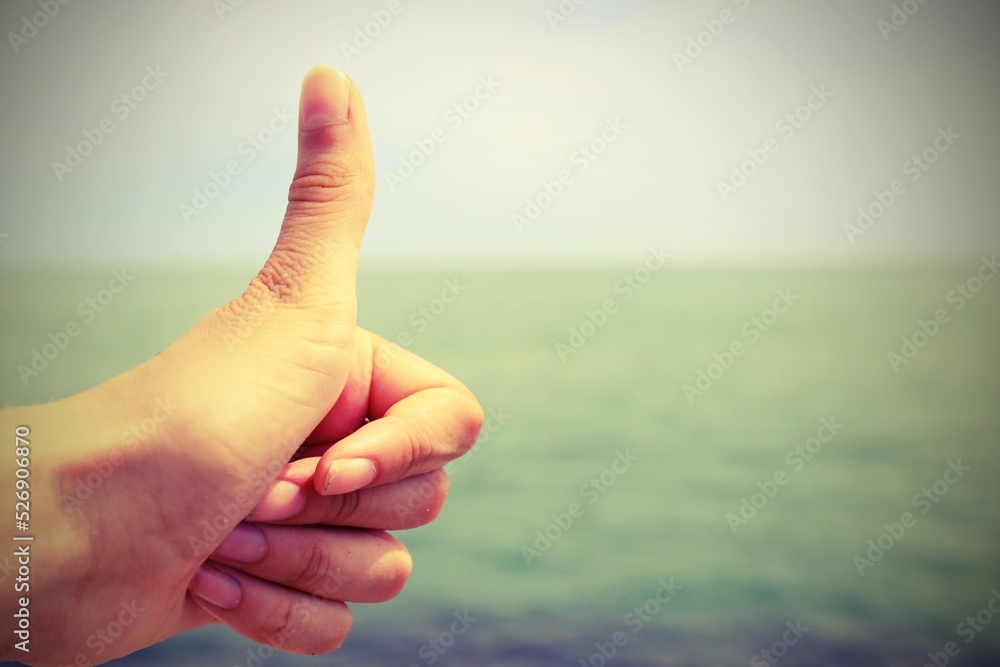 female hand with thumb raised as OK sign with antiqued effect female hand with thumb raised as OK sign with antiqued effect