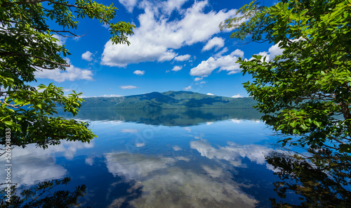 白い雲の浮かぶ鮮やかな青空を湖面に反射する湖。