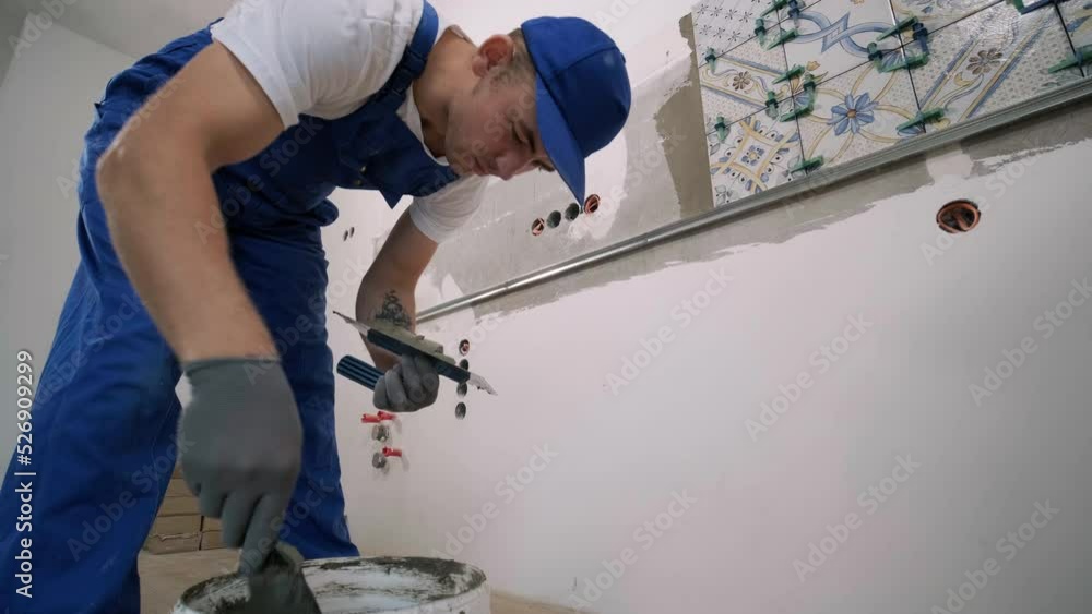Installing ceramic wall tiles - measuring and cutting the pieces. Construction, renovation, repair apartment. Cuts tile. Tile cutting Installing ceramic wall tiles - measuring and cutting the pieces. Construction, renovation, repair apartment. Cuts tile. Tile cutting