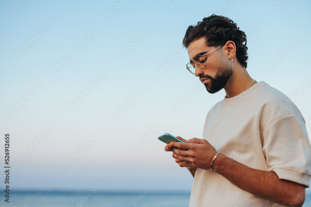 Caucasian man on beach with smartphone Caucasian man on beach with smartphone