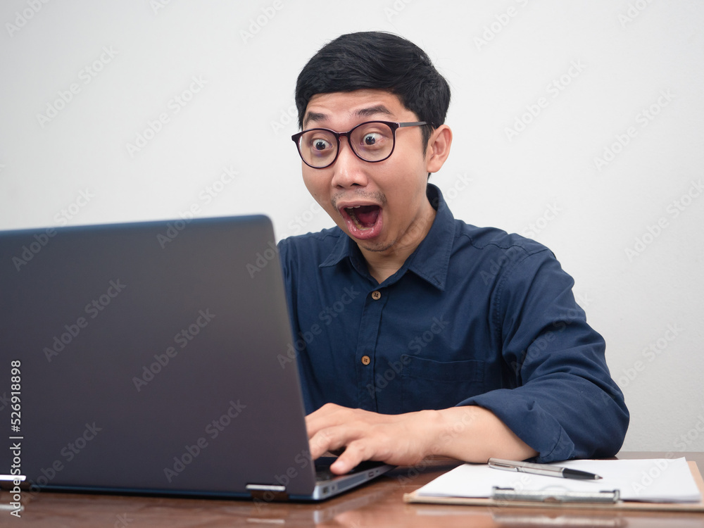 Asian businessman using laptop for working feels amazed Asian businessman using laptop for working feels amazed