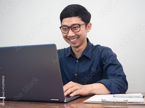 Businessman wear glasses happy with working using laptop at workplace table