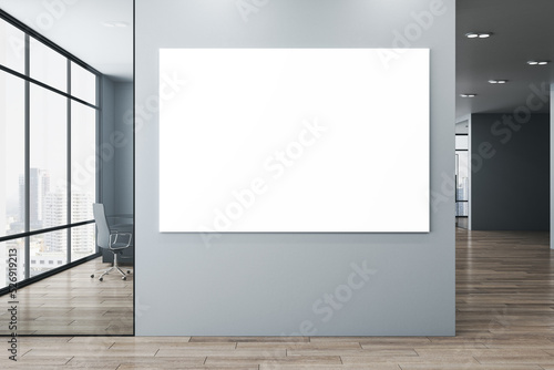 Fotografie, Obraz Modern new office corridor interior with glass windows and city view, wooden flooring and empty white mock up poster on wall