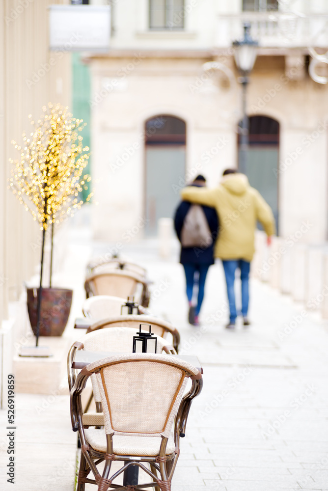 Unfocused couple passing street cafe in the city