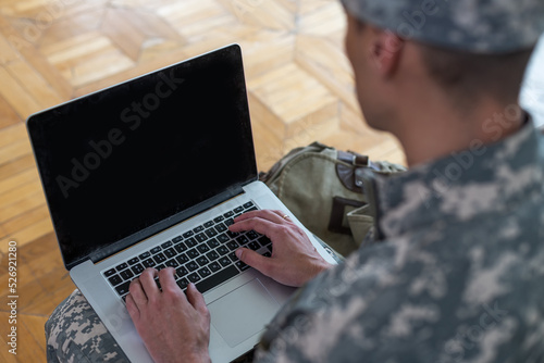 Soldier holding laptop. Military education concept