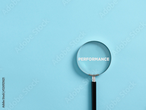 Magnifier focuses on the word performance. Analyzing or reviewing business job or employee performance photo