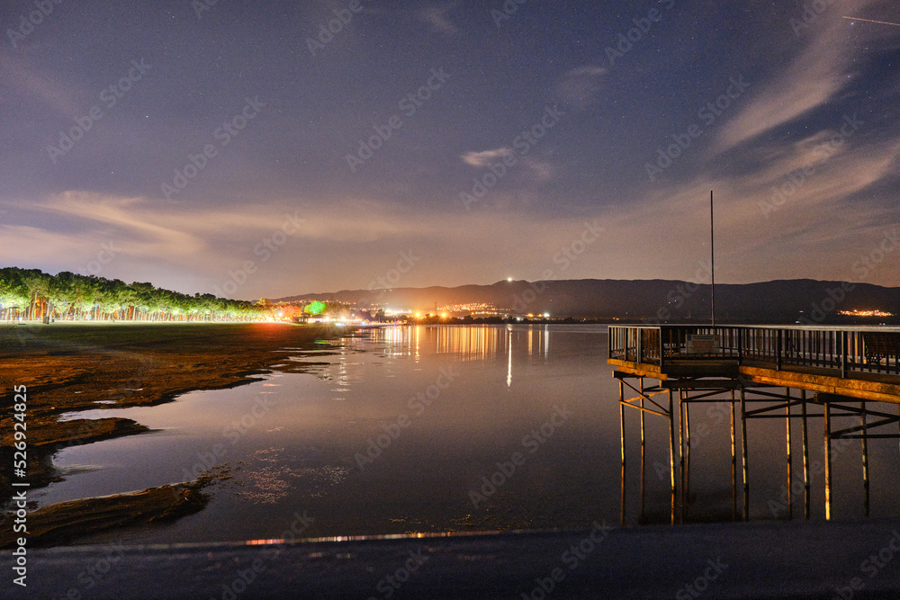 Obraz premium beautiful sunset over the lake iznik, Long exposure photo of lake iznik at night, wooden made pier and reflection on water pond.