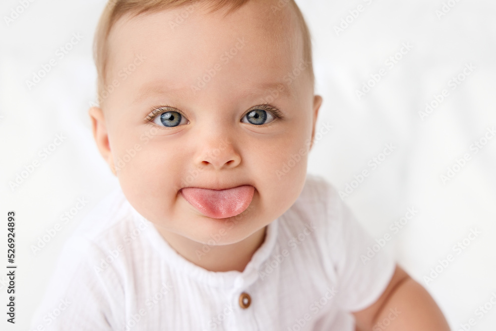 Close up of cute blue-eyed baby sticking out tongue Close up of cute blue-eyed baby sticking out tongue