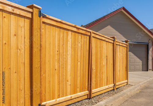 Nice new wooden fence around house. Wooden brown fence. Street photo, nobody