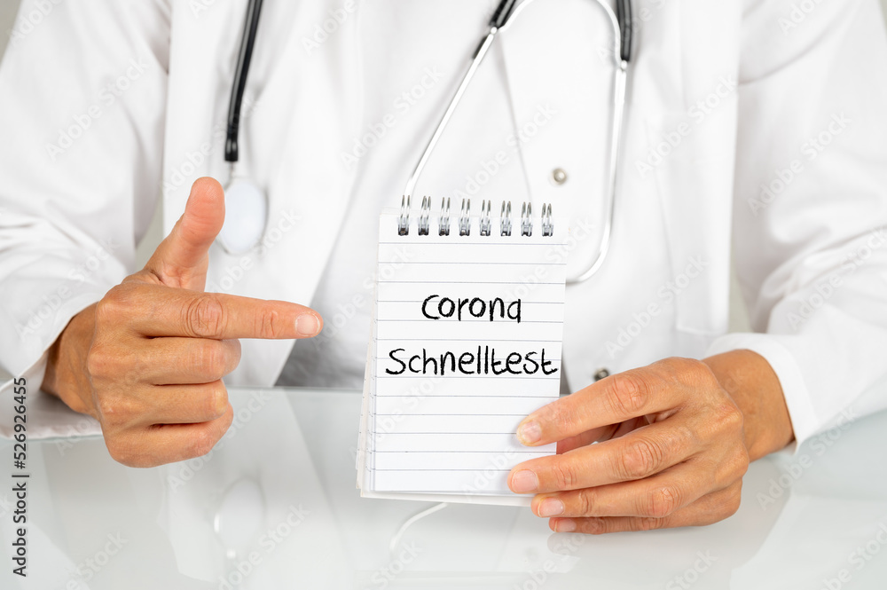 Ärztin zeigt auf einen Notizblock auf dem Corona Schnelltest steht Ärztin zeigt auf einen Notizblock auf dem Corona Schnelltest steht