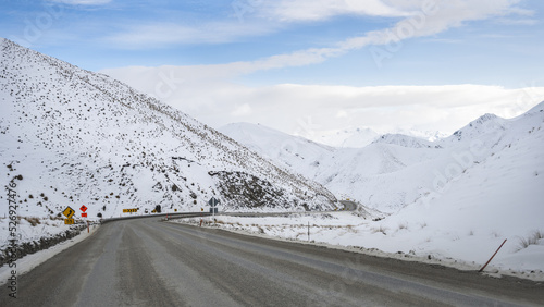 Road to Lindis Pass in winter, mountains covered in snow. South Island.