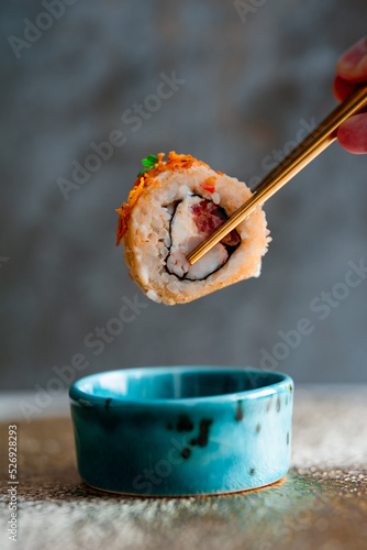 sushi roll chef holding chopsticks