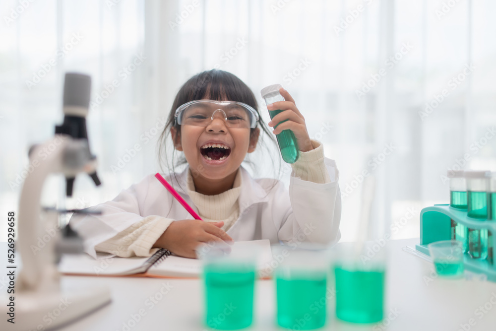 Naklejka premium education, science, chemistry, and children concept - kids or students with test tube making experiment at school laboratory