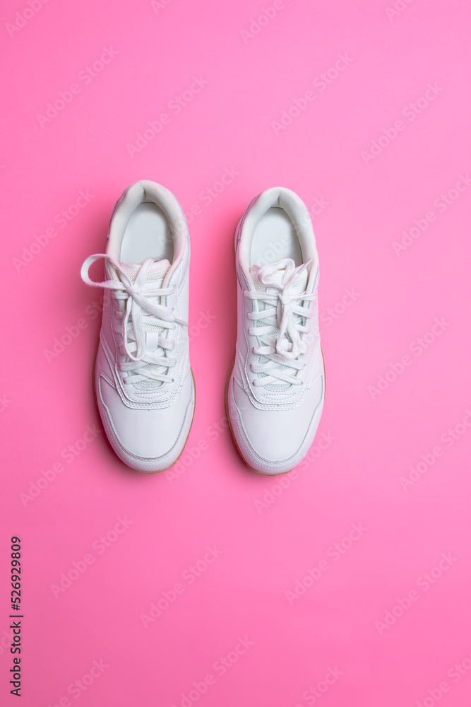 Upper View of Pair of New White Sneakers Over Pink Seamless Background. Upper View of Pair of New White Sneakers Over Pink Seamless Background.