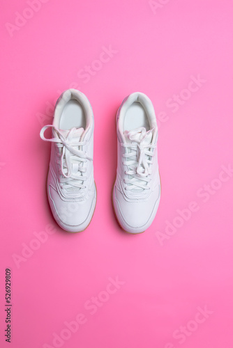 Upper View of Pair of New White Sneakers Over Pink Seamless Background.