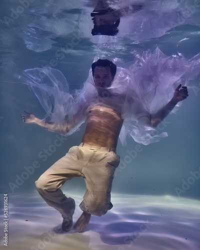 Wallpaper Mural young man in white ribbons and trousers underwater in the pool on a dark background Torontodigital.ca