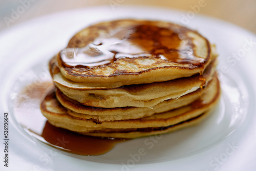 Close up stack of pancakes with maple syrup on plate
 photo