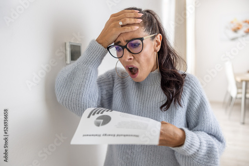 Woman is shocked from the rising energy costs and the bill she received for heat and electricity for her household