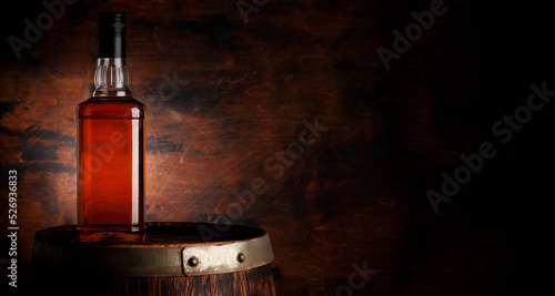 Bottle of whiskey on the old barrel