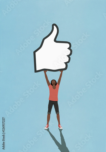 Happy woman holding social media like button on blue background
 photo