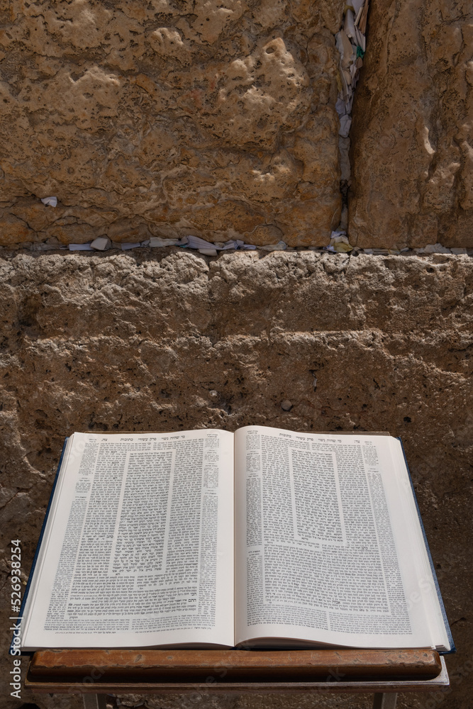 A Talmud open to the text from the tractate Ketubot rests on a prayer